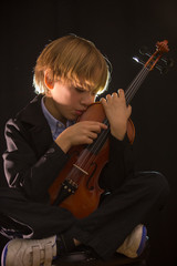 boy hugging his violin, in an attitude of love for music
Boy shows his violin to the camera
