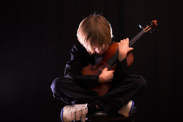 boy hugging his violin, in an attitude of love for music
Boy shows his violin to the camera