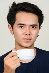 Portrait of young Asian man holding coffee cup