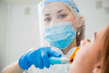Jeune femme dentiste traitant la cavité de remplissage des dents du patient