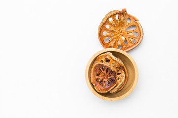 Dry bael fruit in wooden bowl on white background, this dry fruit for making herb drink hot tea or cold drink 