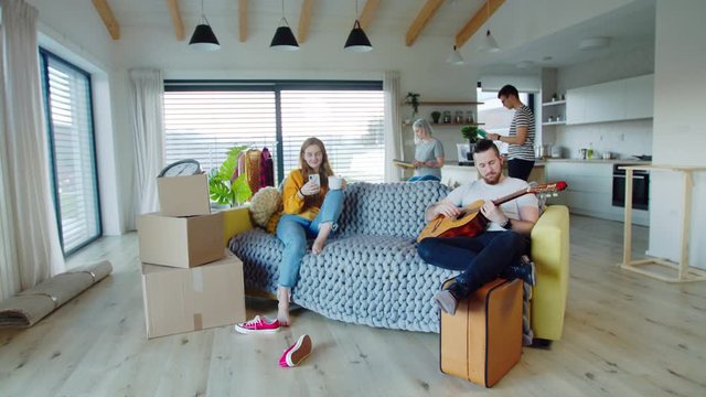 Group of young people with guitar moving in new home, house sharing concept.