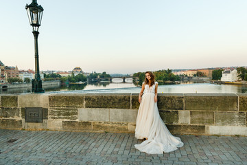 Young bride poses on Charles Bridge. Bride in prague