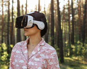 Girl with VR glasses in the forest