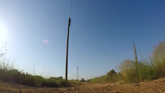 Mountain biker rides bicycle toward and directly above and over camera, static