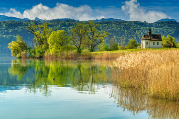 Fototapeta premium The historical St. Meinrad Chappel situated in an idyllic peninsula on the shores of the Upper Zurich Lake near Bollingen, st. Gallen, Switzerland