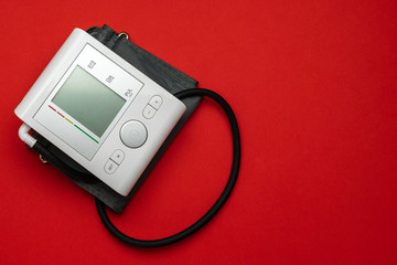 Medical instruments life. Heart hypertension check with sphygmomanometer for doctor, patient. Medical test monitor for blood pressure isolated on red background. Flat lay, top view, copy space.