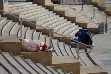 empty seats in a outdoor amphitheater with homeless people