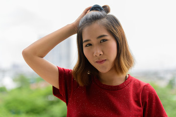 Portrait of young Asian woman with short hair outdoors