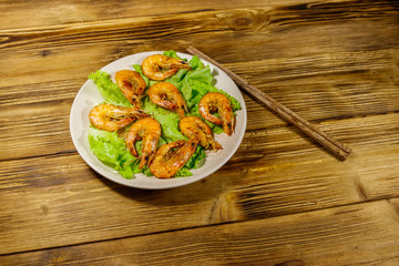 Tasty baked shrimps on a wooden table