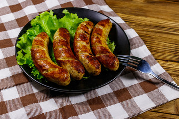 Tasty grilled sausages on a wooden table