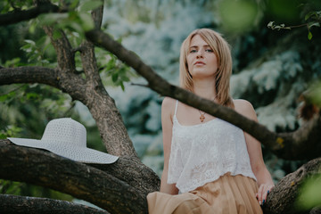 Naklejka premium Cute blonde sits on tree
