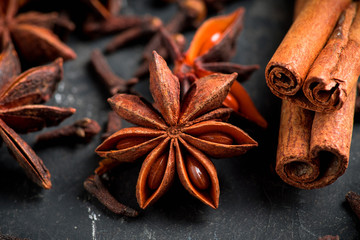 Anise stars and cinnamon sticks on the rustic wooden background. Selective focus. Shallow depth of field. 
