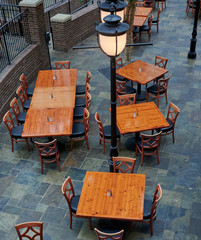 wood tables and chairs in restaurant under light pole