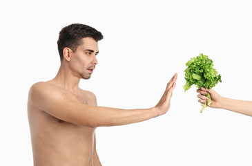 Offering of lettuce to sick man on white background. Concept of anorexia