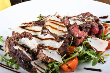 Traditional Italian main dish. Beef tagliata: tender beef rib eye, arugula, cherry tomatoes