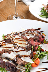 Traditional Italian main dish. Beef tagliata: tender beef rib eye, arugula, cherry tomatoes