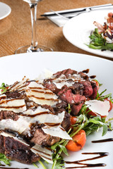 Traditional Italian main dish. Beef tagliata: tender beef rib eye, arugula, cherry tomatoes