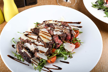 Traditional Italian main dish. Beef tagliata: tender beef rib eye, arugula, cherry tomatoes