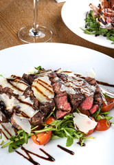 Traditional Italian main dish. Beef tagliata: tender beef rib eye, arugula, cherry tomatoes