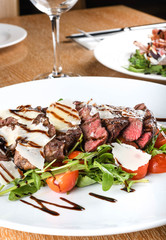 Traditional Italian main dish. Beef tagliata: tender beef rib eye, arugula, cherry tomatoes