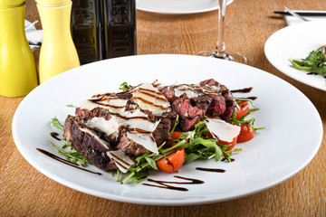 Traditional Italian main dish. Beef tagliata: tender beef rib eye, arugula, cherry tomatoes