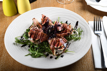Traditional Italian salad made with figs, Prosciutto dry-cured ham or Parma ham sliced prosciutto