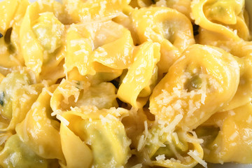 Tortellini with ricotta cheese and spinach, butter, sage sauce, grated parmesan. Parmigiano-Reggiano flakes