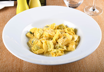 Tortellini with ricotta cheese and spinach, butter, sage sauce, grated parmesan. Parmigiano-Reggiano flakes