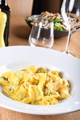 Tortellini with ricotta cheese and spinach, butter, sage sauce, grated parmesan. Parmigiano-Reggiano flakes