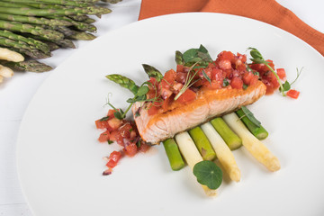 Grilled salmon fish on green and white asparagus