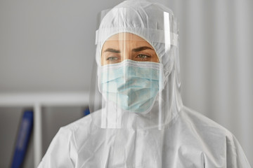 health safety, medicine and pandemic concept - close up of female doctor or scientist in protective wear, medical mask and face shield for protection from virus disease