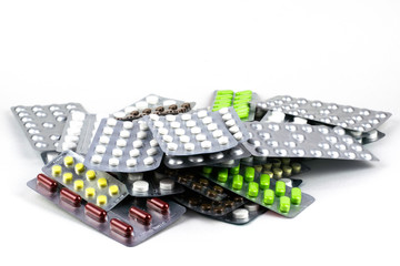 big pile of different pills in blisters on the white background