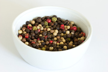 Pepper mix in a bowl on white background.