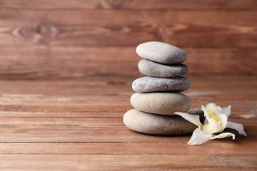 Fototapeta na wymiar Stack of spa stones and flower on wooden background