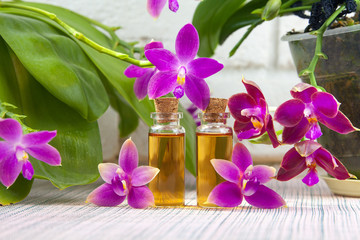 Obraz na płótnie Canvas Essence of orchid flowers on table in beautiful glass jar