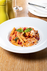 Pasta penne Napoli, traditional italian cuisine dish, chili, tomato and parmesan sauce
