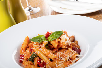 Pasta penne Napoli, traditional italian cuisine dish, chili, tomato and parmesan sauce
