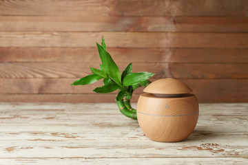 Aroma oil diffuser on wooden background