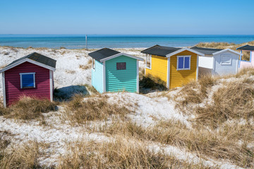 Fototapeta na wymiar Beach huts or bath cottages on Skanor beach dunes and Falsterbo in South Sweden, Skane travel destination. Domestic tourism concept