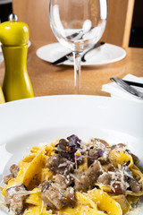 Fresh pappardelle pasta with porcini mushrooms and truffle scent. Parmesan and mozzarella cheese