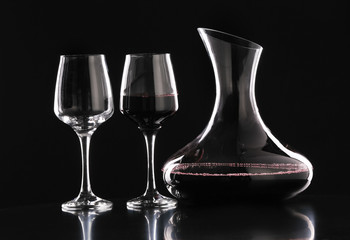 Decanter with wine and glasses on dark background