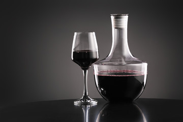 Decanter of wine and glass on dark background