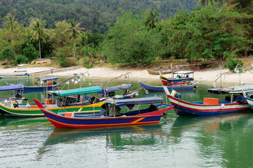 Fototapeta premium Colourful boats docked around tropical beach