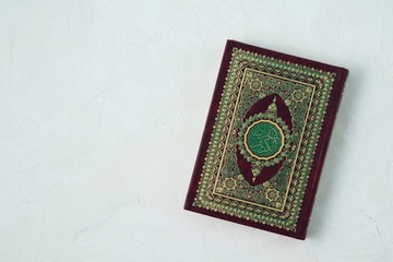 Holy Quran with written arabic calligraphy meaning of Al Quran on white background.