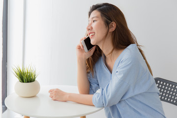 Beautiful of young Asian woman using smartphone while sitting at home, Asia woman mobile phone work from home