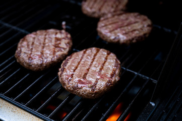 burgers on the bbq grill with potato wedges in pan and giant mushrooms