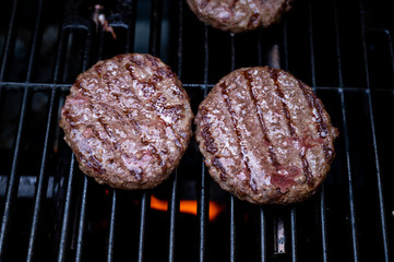 burgers on the bbq grill with potato wedges in pan and giant mushrooms