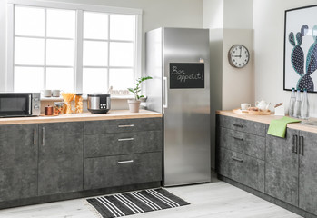 Stylish interior of modern kitchen with big refrigerator