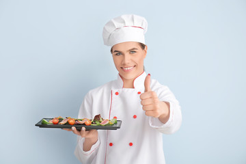 Transgender chef with salad on color background